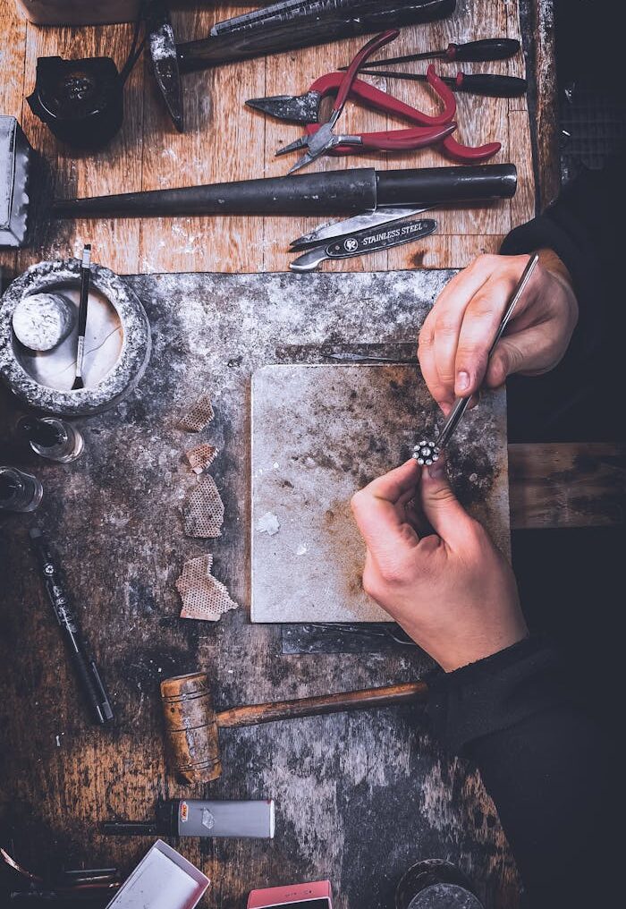 Artisan polishing jewelry on workbench with tools in a workshop in Tekirdağ, Türkiye.