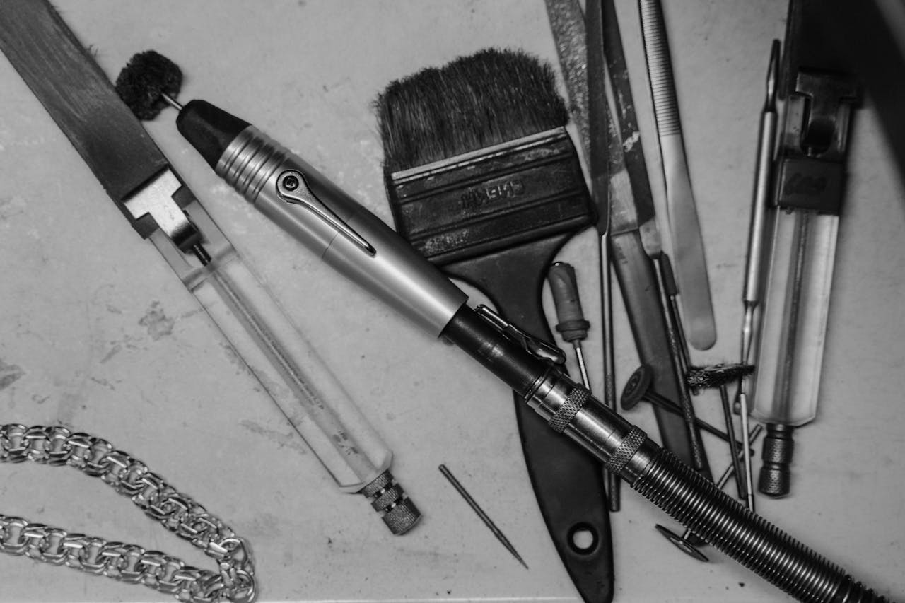 A monochrome image showcasing various tools used in jewelry making, emphasizing craftsmanship.